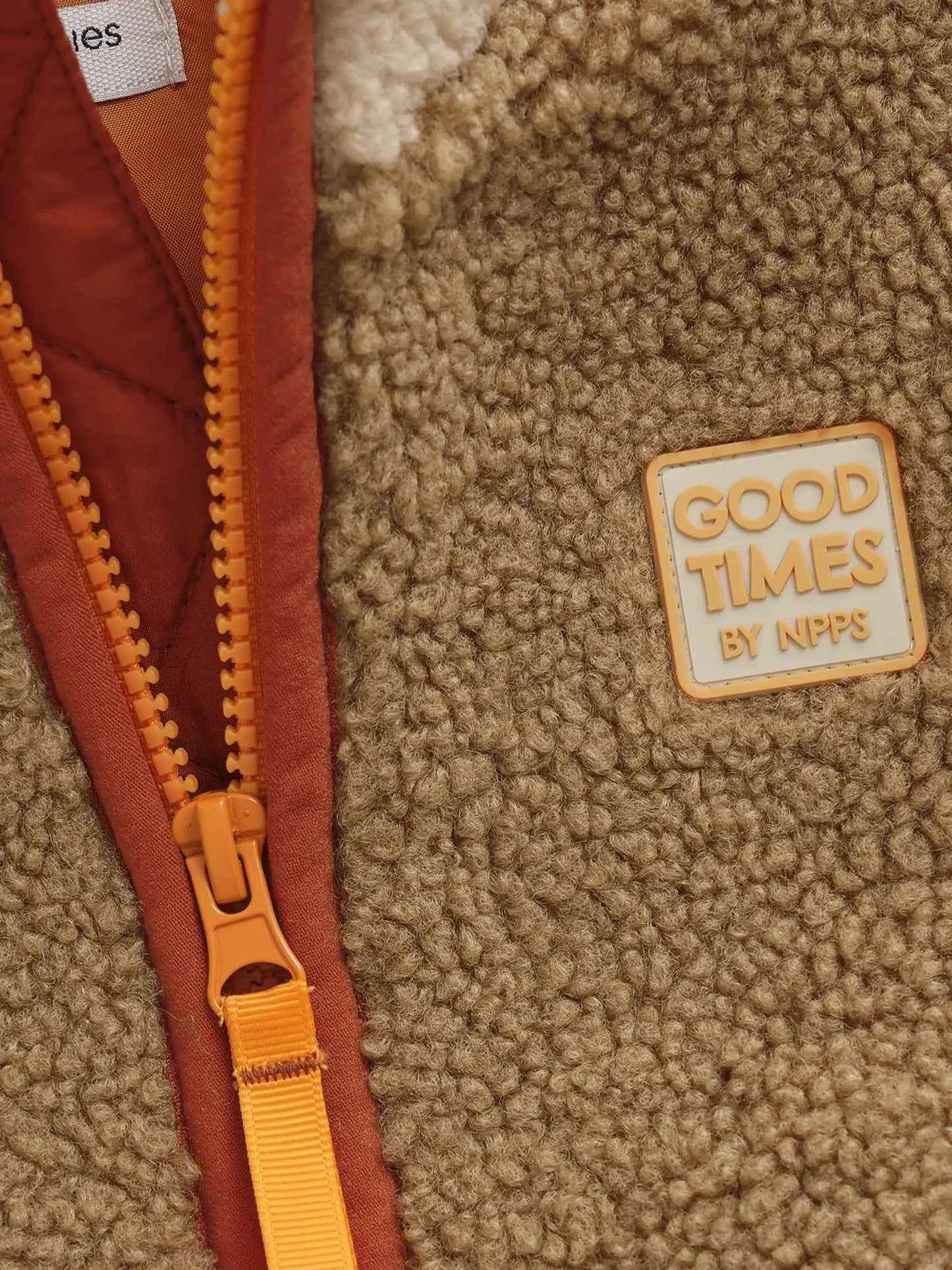 Noppies Fleecejacke in Beige/Braun mit orangefarbenen Reißverschluss-Detail Mokkini Kindermode Teddyjacke